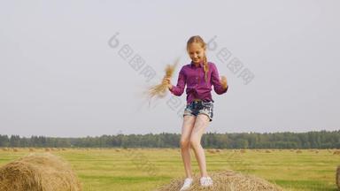 好玩的女孩跳舞有堆栈稻草手收获场<strong>快乐</strong>的少年女孩有趣的干草堆